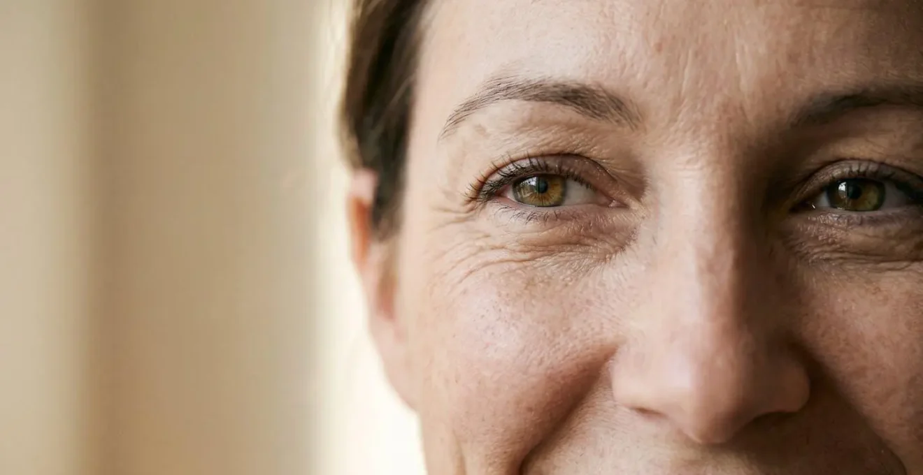 Primo piano naturale del contorno occhi di una donna con espressione serena che evidenzia la zona perioculare in luce morbida