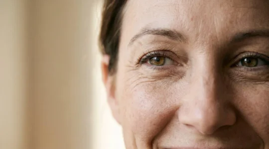 Primo piano naturale del contorno occhi di una donna con espressione serena che evidenzia la zona perioculare in luce morbida