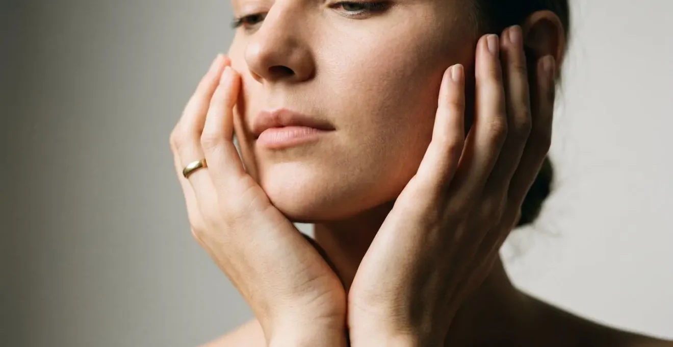 Mani femminili che sfiorano delicatamente il profilo del viso in gesto di cura