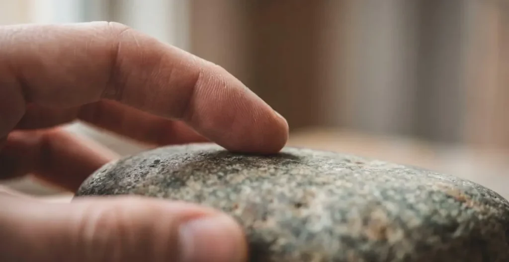 Dettaglio macro di mani in posizione di consapevolezza tattile su superficie naturale Dettaglio macro di mani in posizione di consapevolezza tattile su superficie naturale